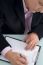 Businessman Writing On Clipboard