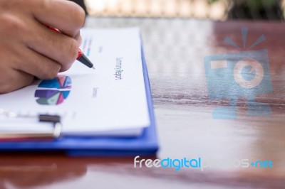 A Business Man Is Using A Pen To Write On The Paper Reported Stock Photo