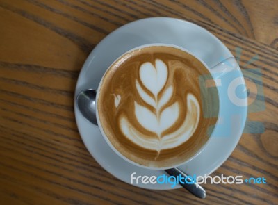 A Cup Of Coffee With Heart Pattern In A White Cup On Wooden Back… Stock Photo