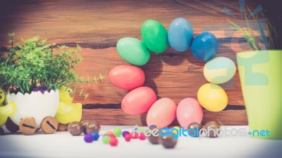 A Few Colorful Easter Eggs As A Flower Shape With Candies And Chocolate And Garden Plants Over Wood Background Happy Easter Stock Photo