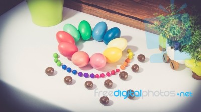 A Few Colorful Easter Eggs As A Flower Shape With Candies And Chocolate And Garden Plants Over Wood Background Left Side View Happy Easter Stock Photo