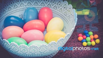 A Few Colorful Easter Eggs In A Blue Basket At The Green Garden With Candies Happy Easter Stock Photo