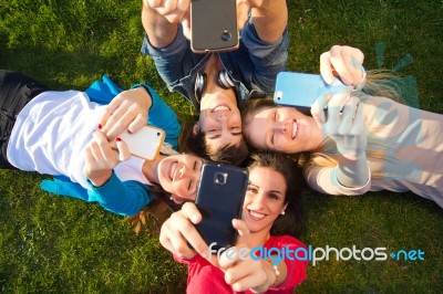 A Group Of Friends Taking Photos With A Smartphone Stock Photo