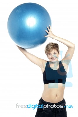 A Healthy Woman Lifting Big Swiss Ball Stock Photo