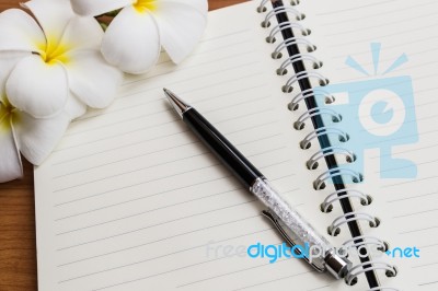 A Pen And Notebook With Flower Stock Photo