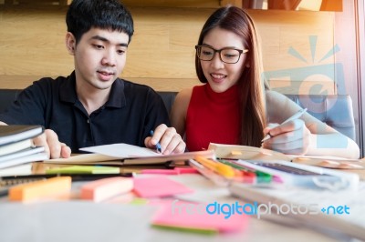 A Teenage Girl And Boy Doing Their Homework Together Stock Photo