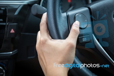 A Woman Hand Pushes The Volume Control Button On A Steering Wheel Stock Photo