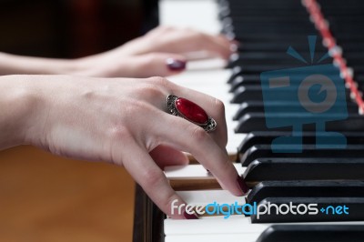 A Woman With Red Ring Playing Piano Stock Photo