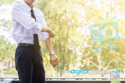 A Young Businessman Is Folding A White Sleeve On His Balcony Stock Photo