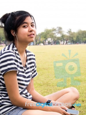 A Young Girl With Headphones Outdoors. Listening Music Stock Photo