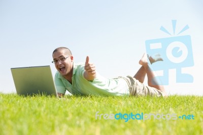 A Young Men Sit On The In The Park Using A Laptop Stock Photo