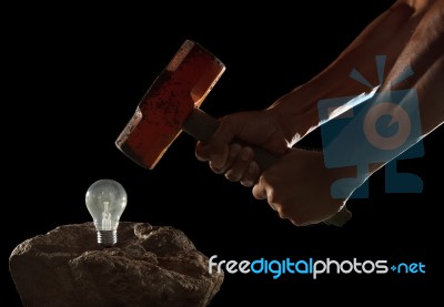 Abstract Of Hand Holding Heavy Hammer To Breaking Light Bulb On Stock Photo