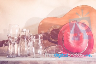 Acoustic Guitar And Assorted Glass Bottles On Wooden Table. Retro Style Stock Photo