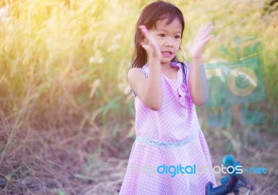 Adorable Little Girl Laughing In A Meadow - Happy Girl At Sunset… Stock Photo