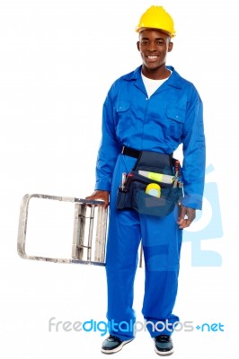 African Builder Holding Step Ladder Stock Photo