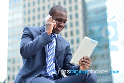 African Executive With Tablet Pc And Cellphone Stock Photo