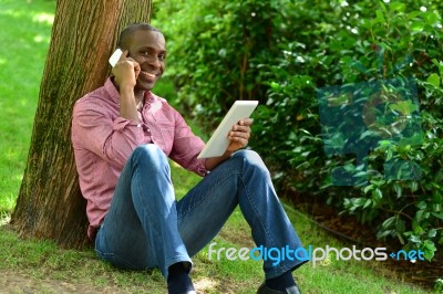 African Man With Smart Phone And Tablet Stock Photo