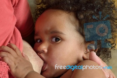 African Mother Feeding Her Child Stock Photo