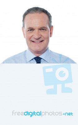 aged Businessman behind empty sign Stock Photo