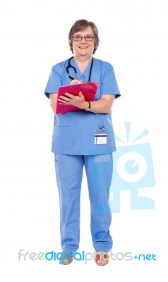 aged surgeon Writing Report Stock Photo