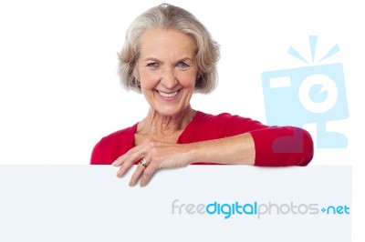 Aged Woman Standing Behind Blank Billboard Stock Photo