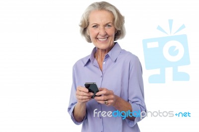 Aged Woman Texting On Her Mobile Phone Stock Photo