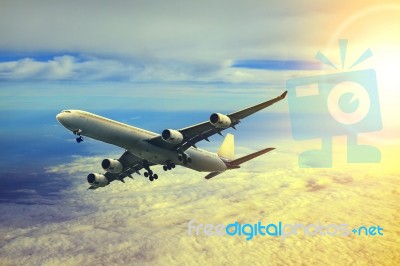 Air Plane Flying Over Cloud Scape And Sun Light Behind Stock Photo