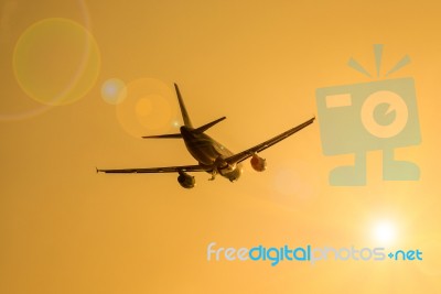 Airplane And Sunbeam With Lens Flare Effect On Orange Background… Stock Photo