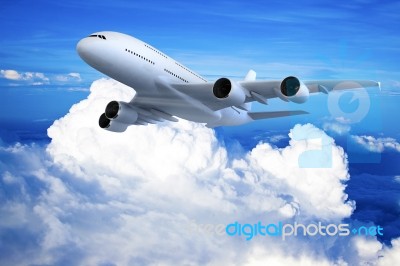 Airplane Flying In The Blue Sky Stock Photo