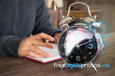 Alarm Clock On Wooden Work Table Stock Photo