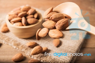 Almond In Wooden Spoon Spilling On Table Stock Photo