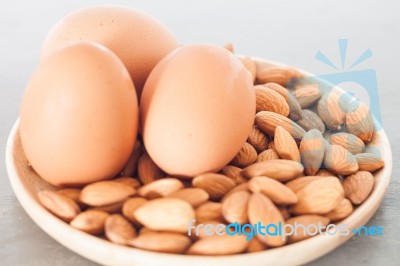 Almond Nuts And Eggs On Wooden Plate Stock Photo