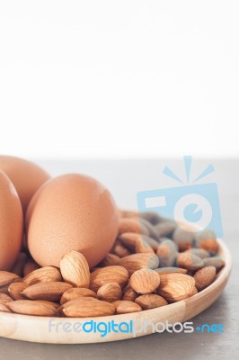 Almond Nuts And Eggs On Wooden Plate Stock Photo