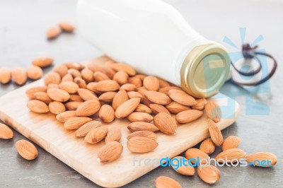 Almond Nuts On Wooden Plate With Milk Stock Photo