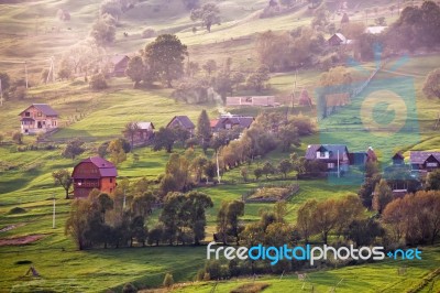 Alpine Village In Mountains. Smoke And Haze Over Hills Stock Photo