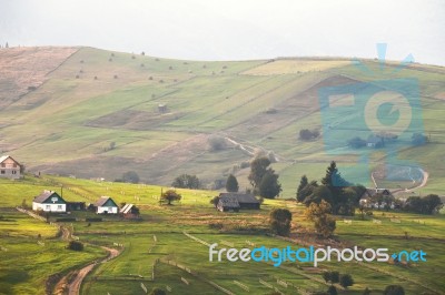 Alpine Village In Mountains. Smoke And Haze Over Hills Stock Photo