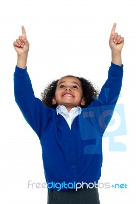 Amazed Young School Girl Indicating Upwards Stock Photo