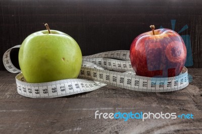 An Apple Surrounded By A Measuring Tape Tailor On Wood Stock Photo