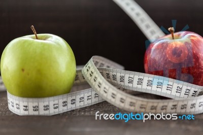 An Apple Surrounded By A Measuring Tape Tailor On Wood Stock Photo