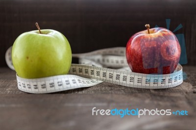 An Apple Surrounded By A Measuring Tape Tailor On Wood Stock Photo