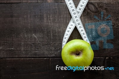 An Apple Surrounded By A Measuring Tape Tailor On Wood Stock Photo