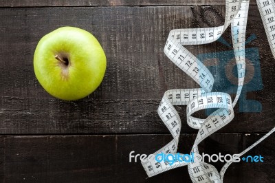 An Apple Surrounded By A Measuring Tape Tailor On Wood Stock Photo