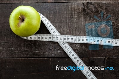 An Apple Surrounded By A Measuring Tape Tailor On Wood Stock Photo