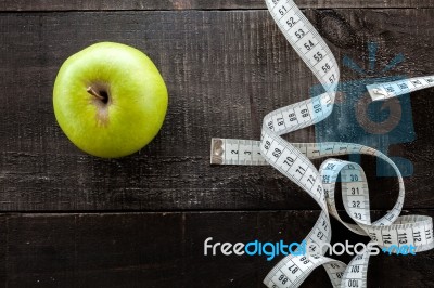 An Apple Surrounded By A Measuring Tape Tailor On Wood Stock Photo