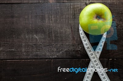 An Apple Surrounded By A Measuring Tape Tailor On Wood Stock Photo