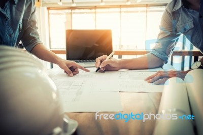 Architects Engineer Discussing At The Table With Blueprint - Clo… Stock Photo