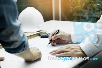 Architects Engineer Discussing At The Table With Blueprint - Clo… Stock Photo