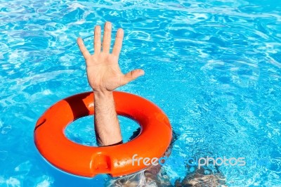 Arm Through Orange Buoy In Swimming Pool Stock Photo