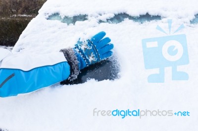 Arm With Glove Removing Snow From Car Window Stock Photo