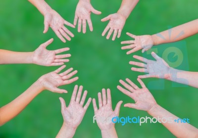 Arms Of Children Together In Circle On Green Background Stock Photo